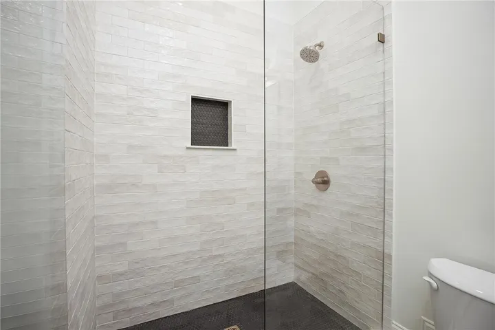 A sleek, tiled shower with a convenient built-in niche and a modern glass enclosure.