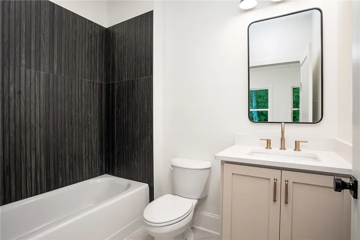 A well-appointed bathroom with striking dark tile walls and a modern vanity.