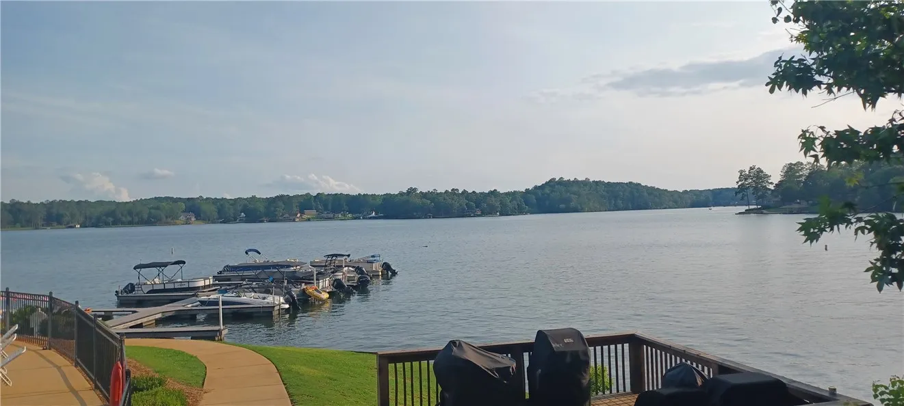A tranquil lake view from a spacious wooden deck, with a private boat dock visible.