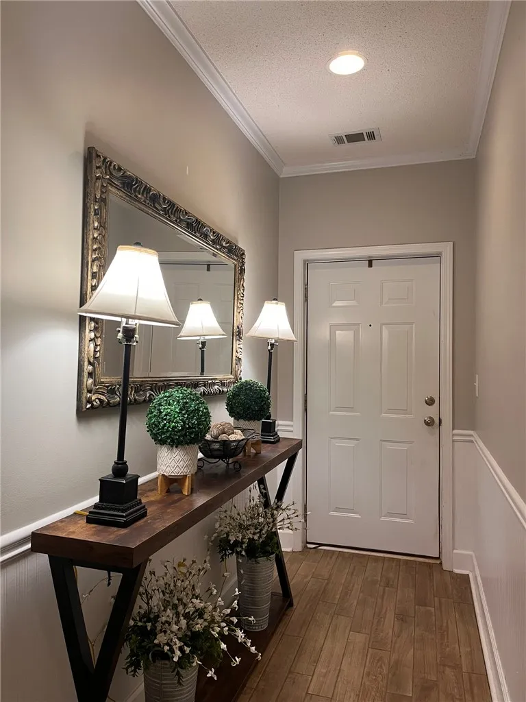 A welcoming entryway with recessed lighting and crown molding offers a warm first impression.