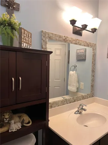A well-appointed vanity with a clean basin, complemented by a mosaic-framed mirror and task lighting.