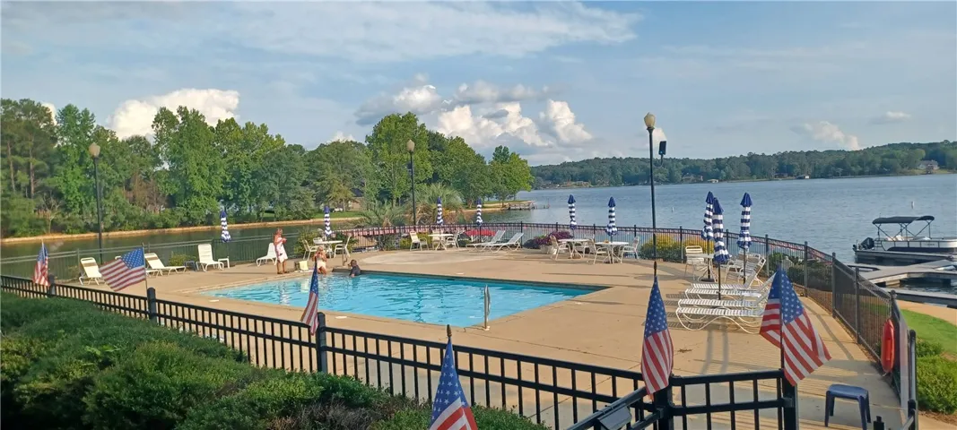 A tranquil lakeside oasis features a sparkling pool and a convenient boat dock, perfect for waterfront recreation.