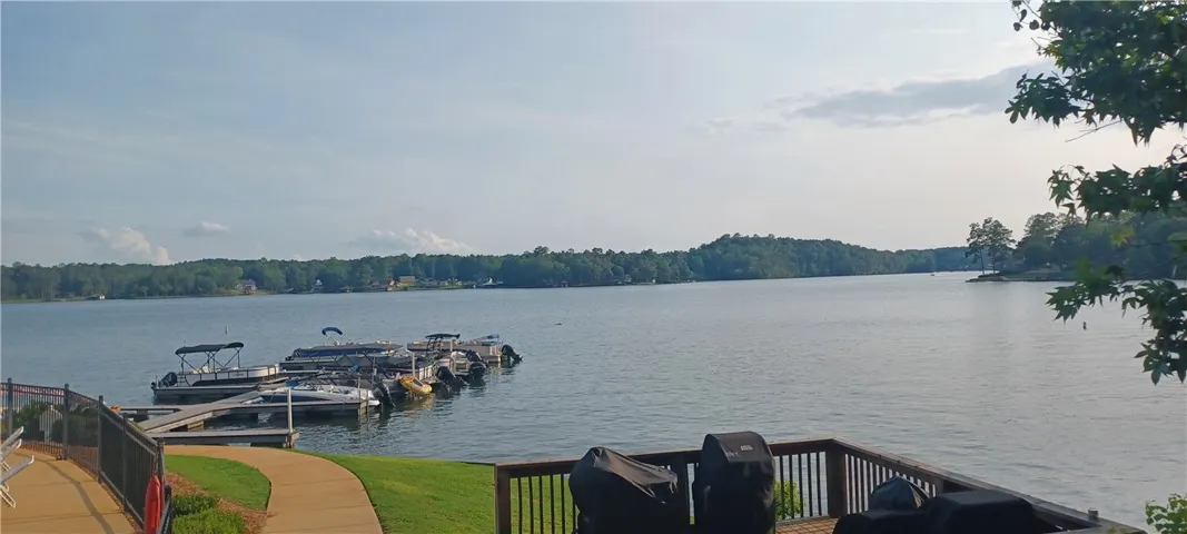 A tranquil lake view from a spacious wooden deck, with a private boat dock visible.