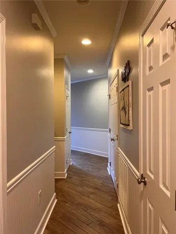 A well-lit corridor with recessed lighting guides visitors through this comfortable residence.