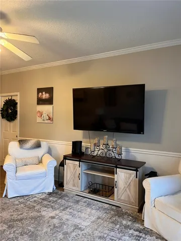 Relax in this comfortable living room, featuring a classic wainscoting accent wall.