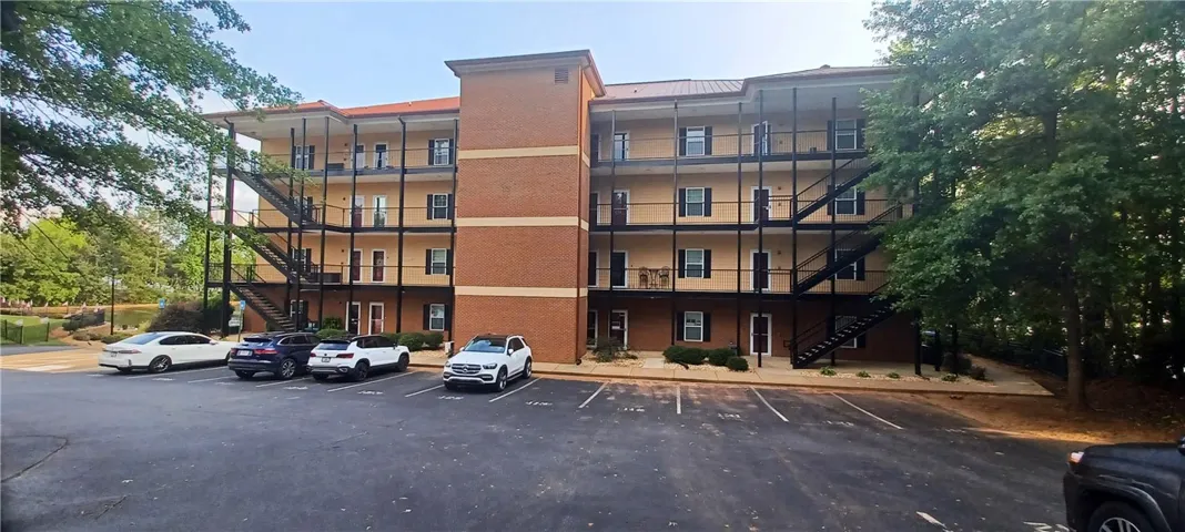 A well-maintained apartment complex featuring multiple stories and a convenient parking area.