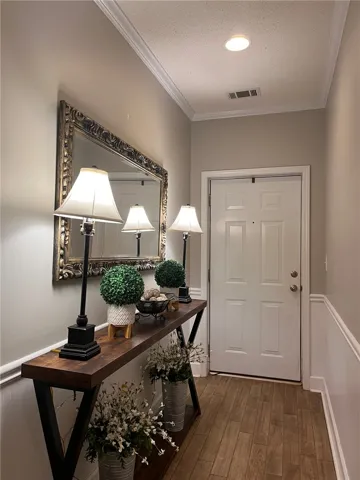 A welcoming entryway with recessed lighting and crown molding offers a warm first impression.