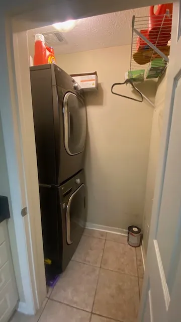 A compact laundry room features a stacked washer and dryer, optimizing space efficiency.