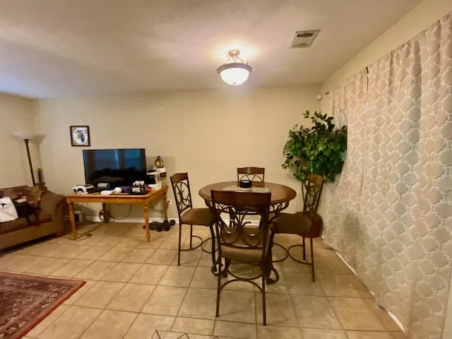 A versatile space for dining and relaxation, complete with tile flooring and ample natural light.
