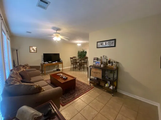 An inviting interior space features a dining area, living room, and tiled flooring.