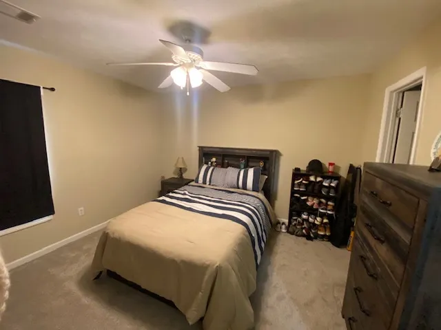 Well-lit sleeping quarters with a ceiling fan, providing comfort and simple style.