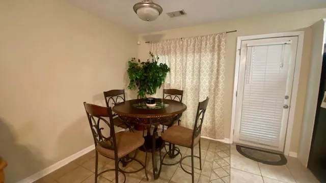 Dine in this well-lit eating area featuring a charming ceiling light fixture and access to the outdoors.