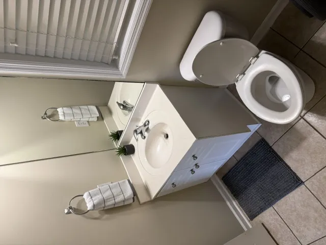 Tiled flooring and a practical vanity with integrated sink define this well-appointed bathroom.