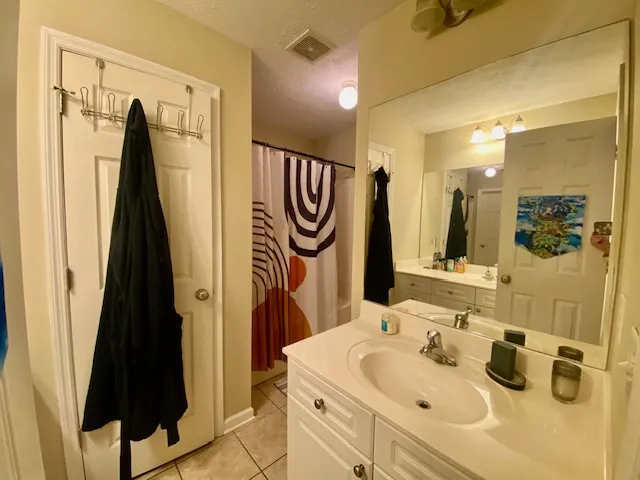 A well-lit bathroom features a vanity with ample counter space and a shower/tub combination.