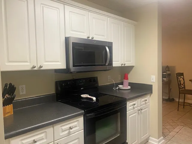 Well-appointed kitchen offering modern appliances and ample white cabinetry for storage.