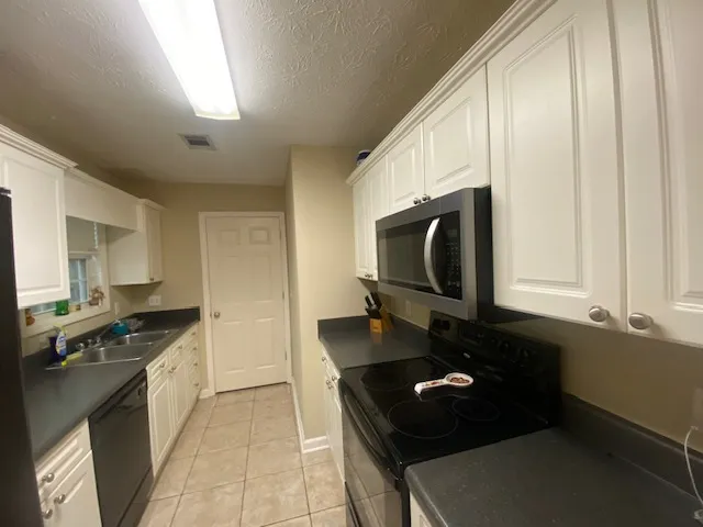 Functional kitchen with ample cabinet space, offering practical cooking and storage solutions.