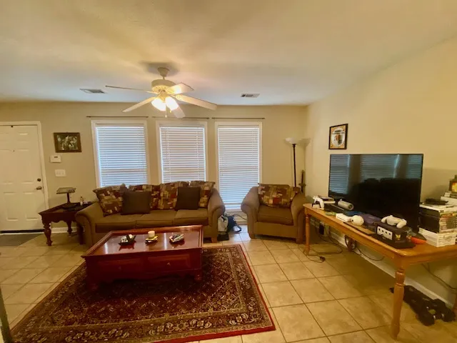 Relax in this living area featuring cool tile flooring and plentiful natural light.