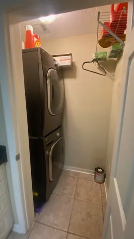 A compact laundry room features a stacked washer and dryer, optimizing space efficiency.