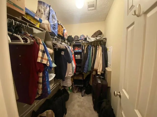 A well-organized walk-in closet offers extensive shelving and hanging space.