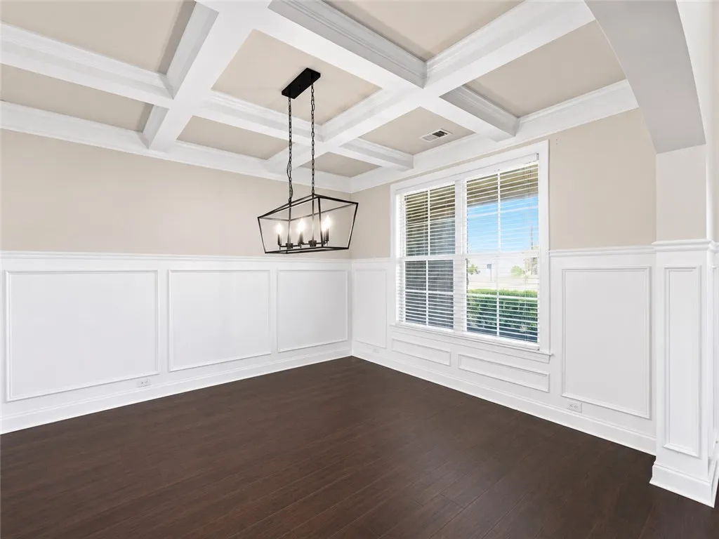Elegant coffered ceilings and rich wood flooring define this inviting dining room space.