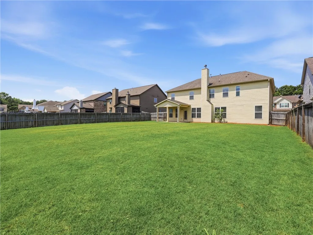 An expansive fenced yard provides ample space for recreation, bordered by a charming neighborhood.
