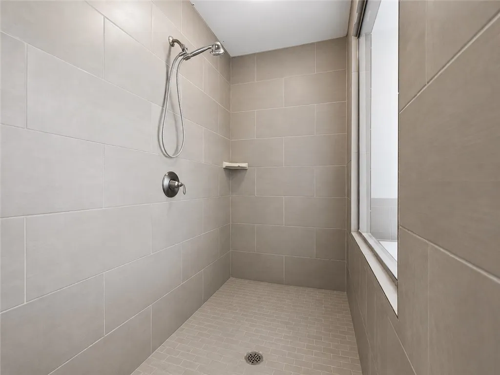 A well-appointed shower stall features modern tile work and sleek fixtures.