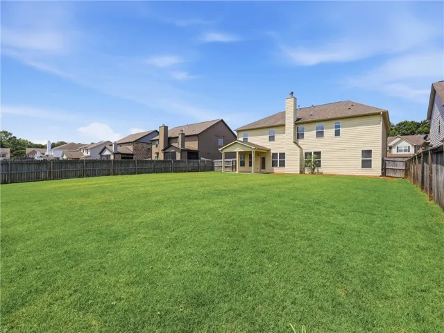 An expansive fenced yard provides ample space for recreation, bordered by a charming neighborhood.