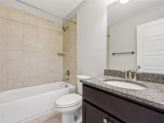 Elegant granite counters and a tile-surrounded tub create a serene bath retreat.
