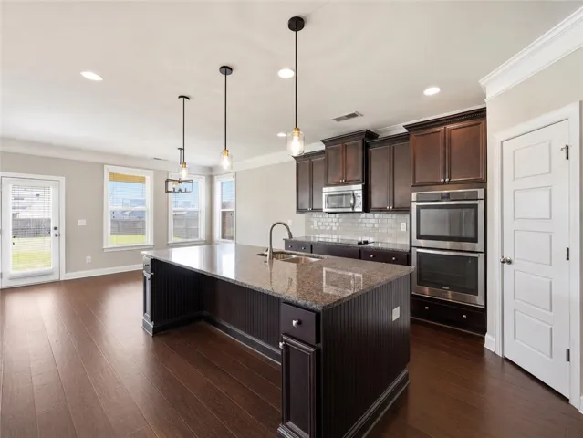 A well-appointed kitchen island with gleaming countertops overlooks the expansive living space.