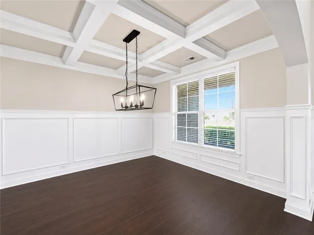 Elegant coffered ceilings and rich wood flooring define this inviting dining room space.