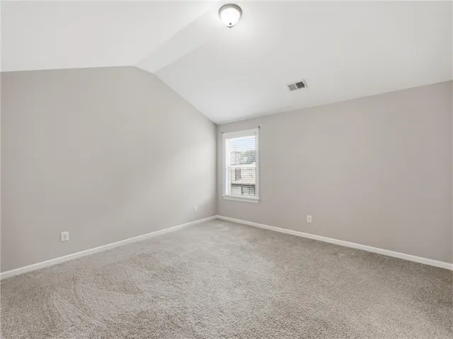 A well-lit bedroom offering a cozy retreat with soft carpeting and an inviting atmosphere.