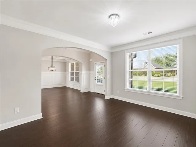 Elegant dark hardwood floors extend through this formal dining area and adjacent entryway.