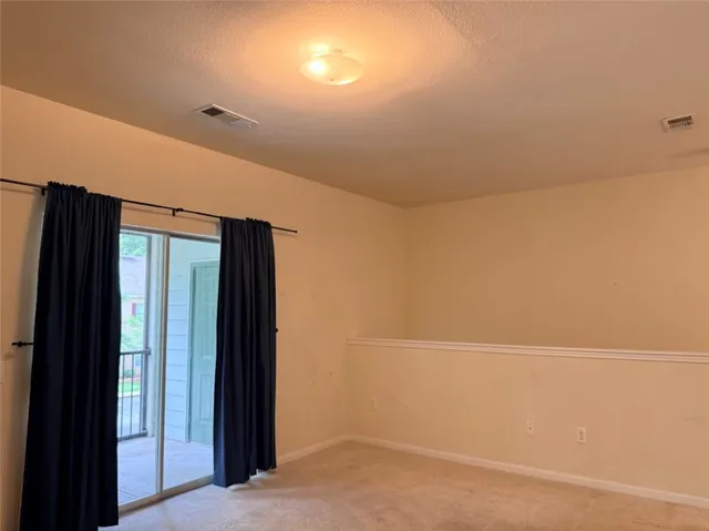 Sliding glass doors open to a private balcony, offering seamless indoor-outdoor living.