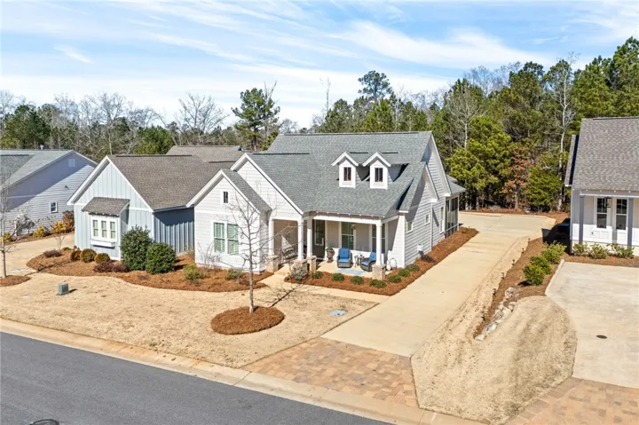 A charming single-story residence with dormer windows, offering a welcoming front porch and well-maintained landscaping.