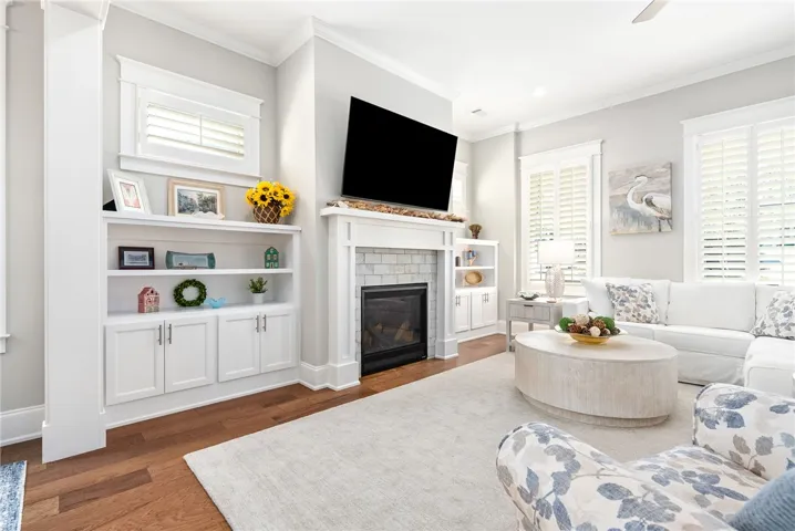 Built-in shelving and a cozy fireplace create a welcoming, well-appointed gathering space.