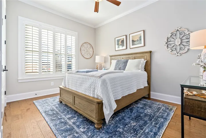 Well-lit sleeping quarters with rich hardwood flooring and classic shuttered windows.