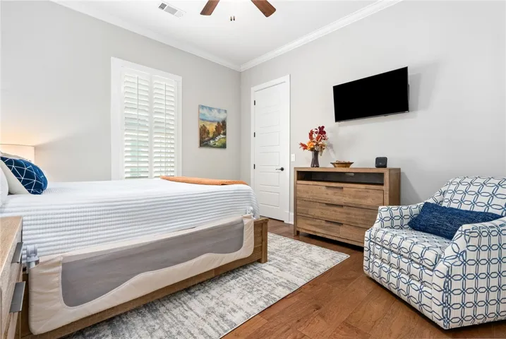 Hardwood floors and bright windows create a cheerful bedroom retreat.