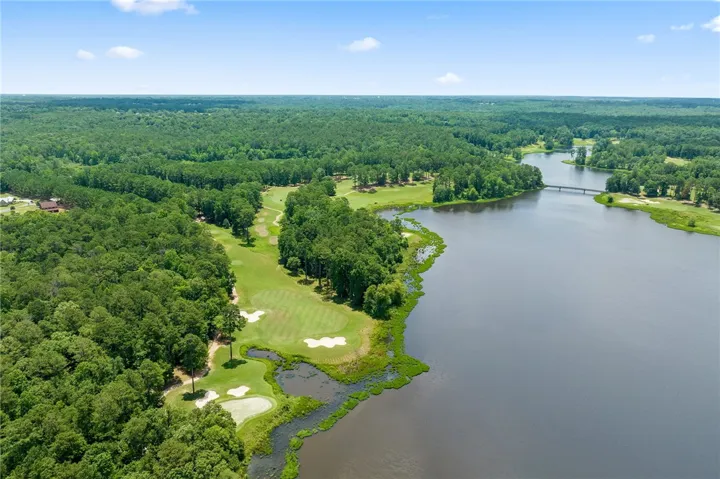 A tranquil lake and a vibrant golf course blend seamlessly with lush, natural surroundings.