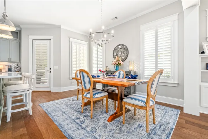 Hardwood floors and a classic chandelier illuminate this inviting dining space.