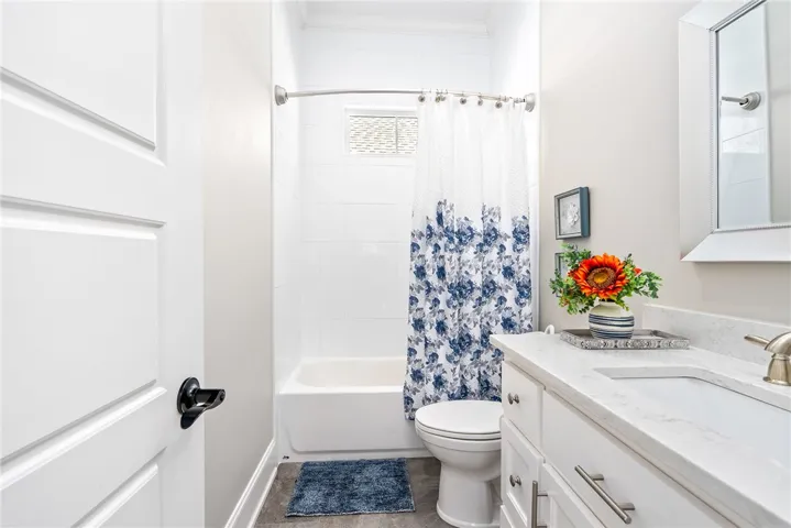 A well-appointed bathroom offers a clean tub-shower combination, a vanity with a bright countertop, and essential fixtures.