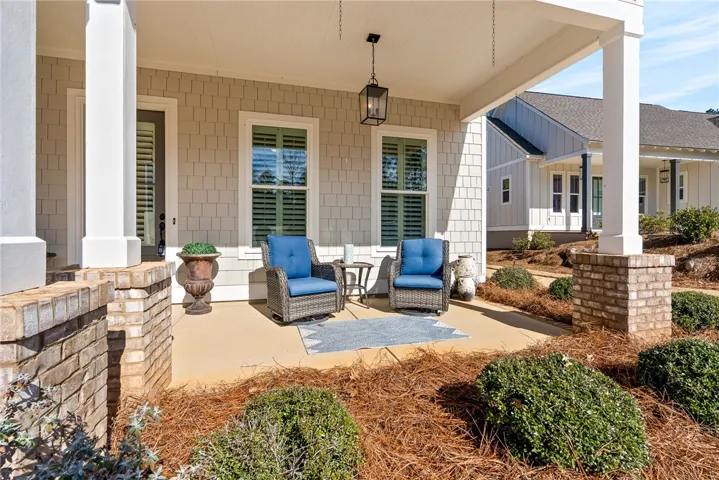 A welcoming covered porch with ample seating offers an ideal spot for relaxation and neighborhood engagement.