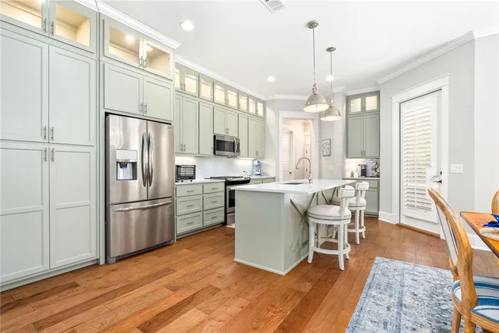 Culinary dreams come alive in this kitchen, featuring stainless steel appliances and an inviting island with a breakfast bar.