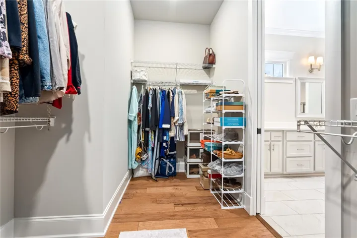 Ample storage solutions and rich wood flooring define this practical closet space.
