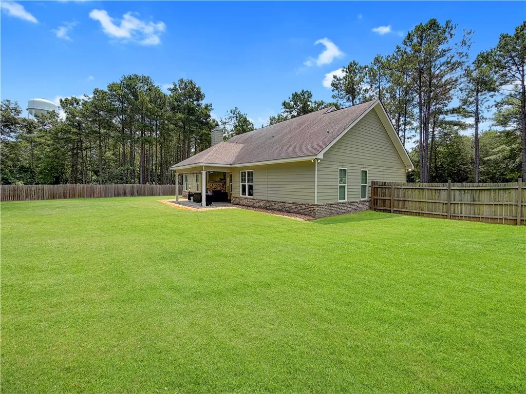 A spacious backyard with a covered patio offers ample room for outdoor activities.