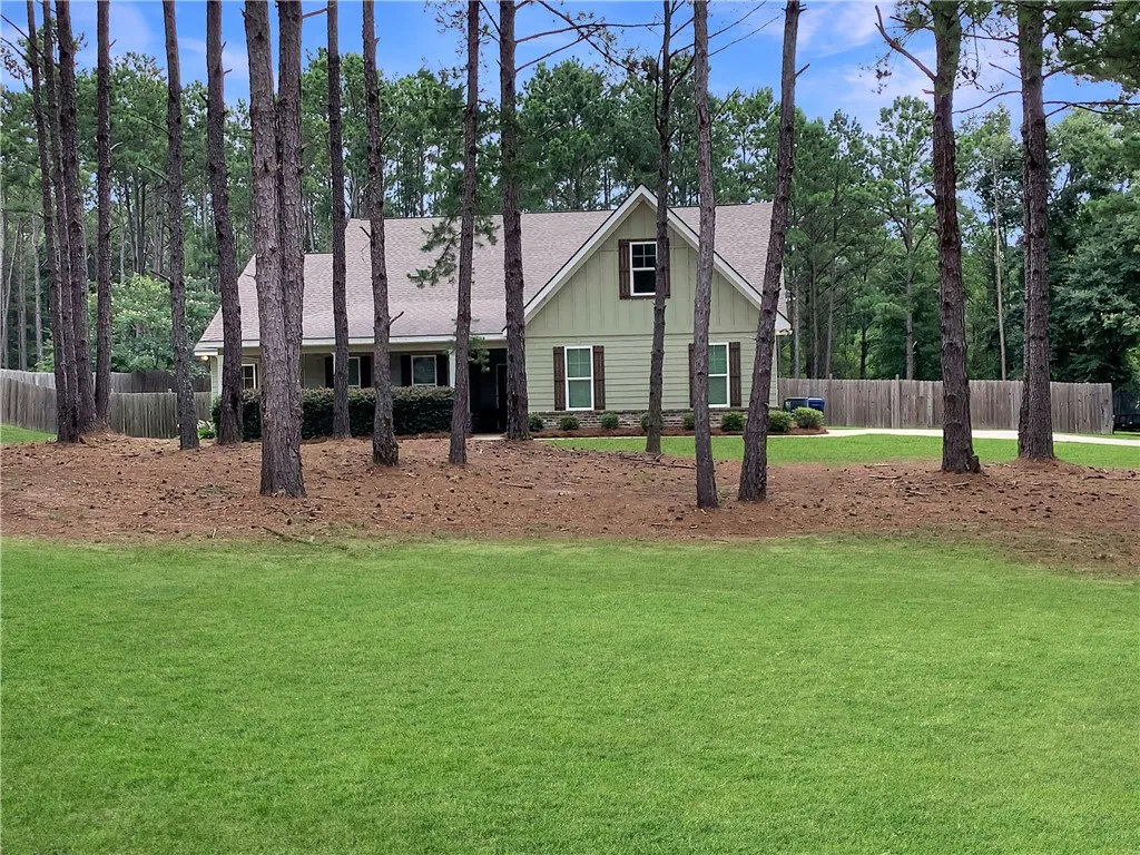 A private estate with a tranquil yard, surrounded by mature trees and verdant landscaping.