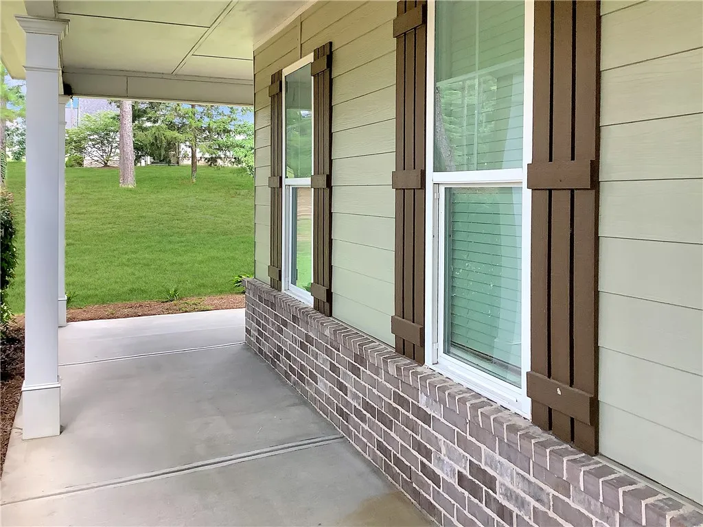 A welcoming covered porch with a durable concrete surface extends an invitation to outdoor living.