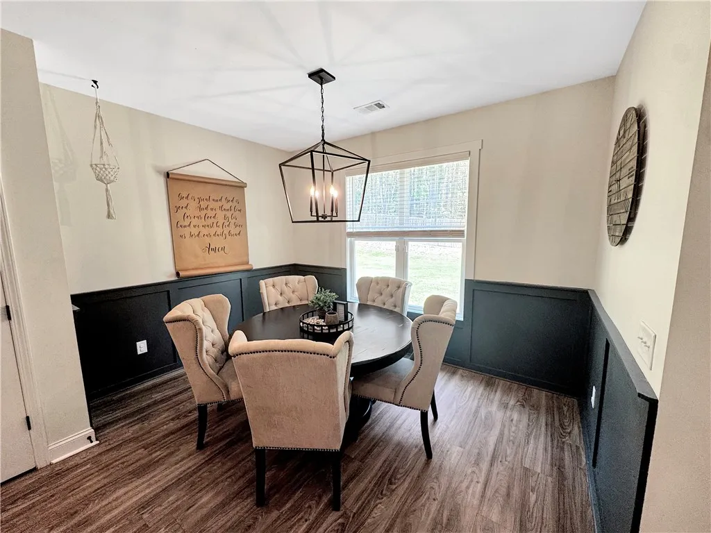 A warm and inviting dining space, featuring board and batten wall details and a chic geometric chandelier.