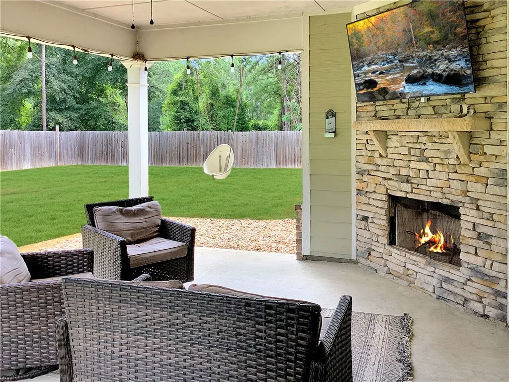 An inviting outdoor living area awaits, complete with a cozy fireplace and verdant private yard.