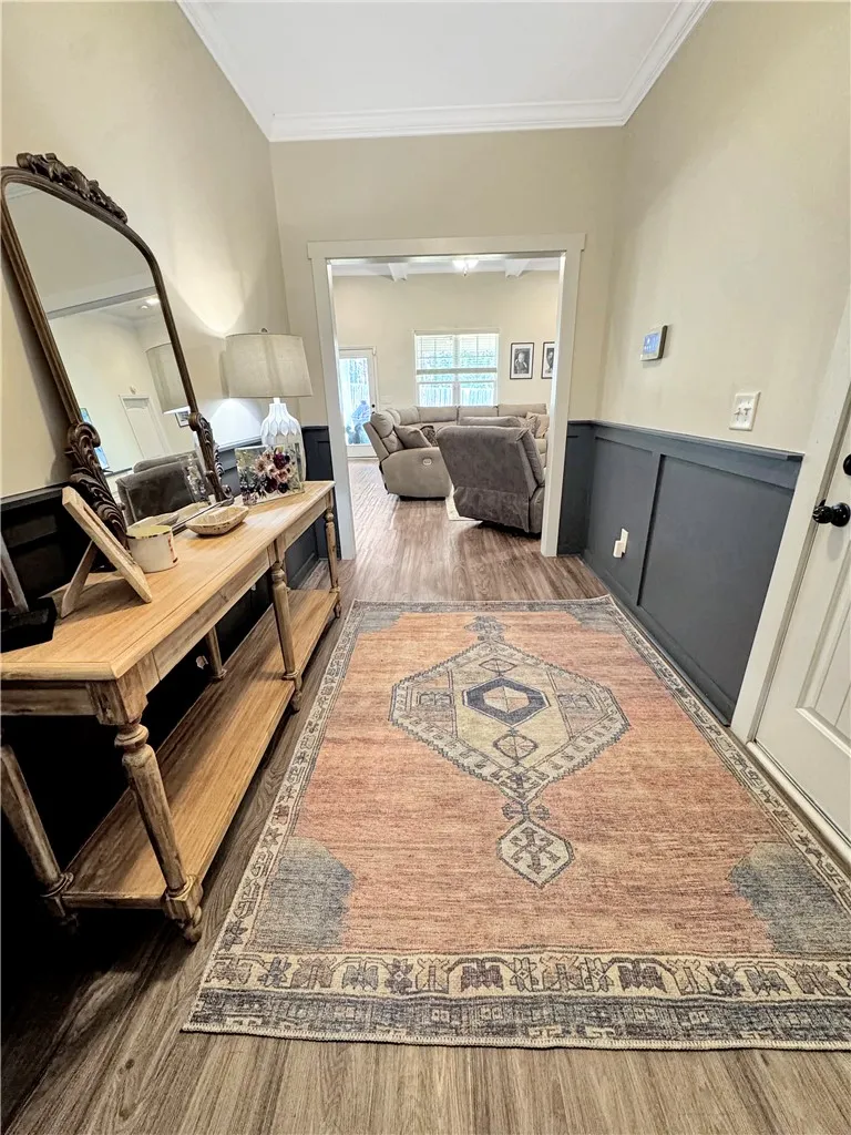 A welcoming entryway with rich wood-look flooring transitions smoothly into the open living area.