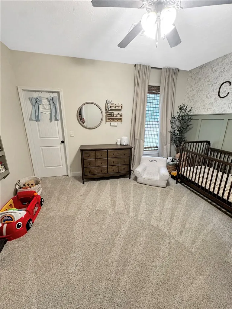 A comforting retreat, this bedroom offers carpet flooring and a ceiling fan for year-round comfort.